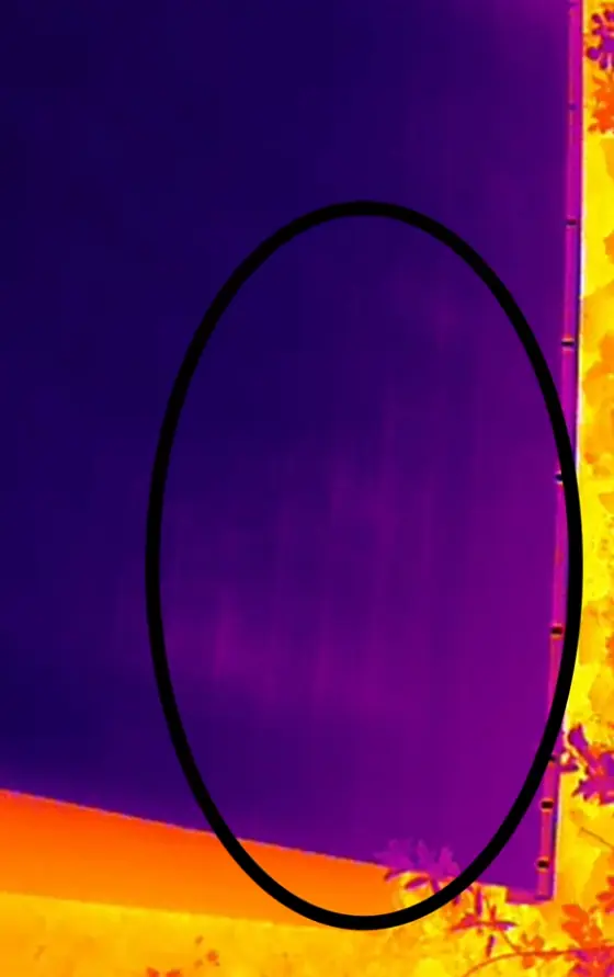 Relevé infrarouge d'une paroi, une ellipse noire tracée sur l'image délimite une zone plus froide au-dessus d'une bande chaude.
